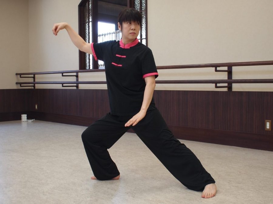 弓歩のポーズをとる気功太極拳講師・理緒（講師歴20年以上）。初心者向けの無理のないレッスン