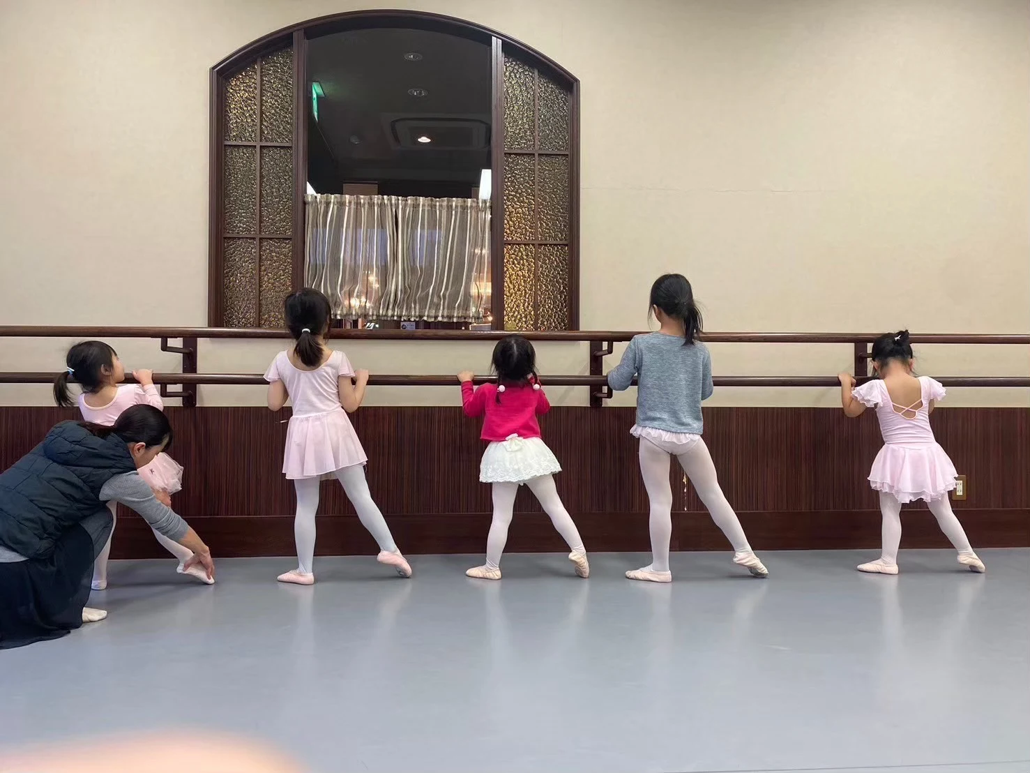 バーにつかまる子どもたちと、足元を支える先生